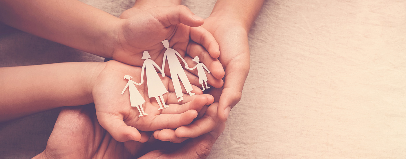 hands holding paper cut outs of people